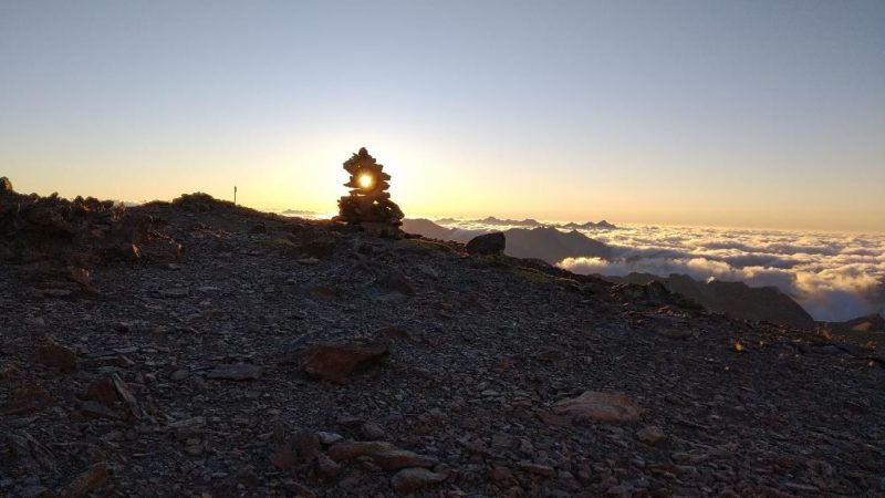 coucher soleil derrière cairn sommet